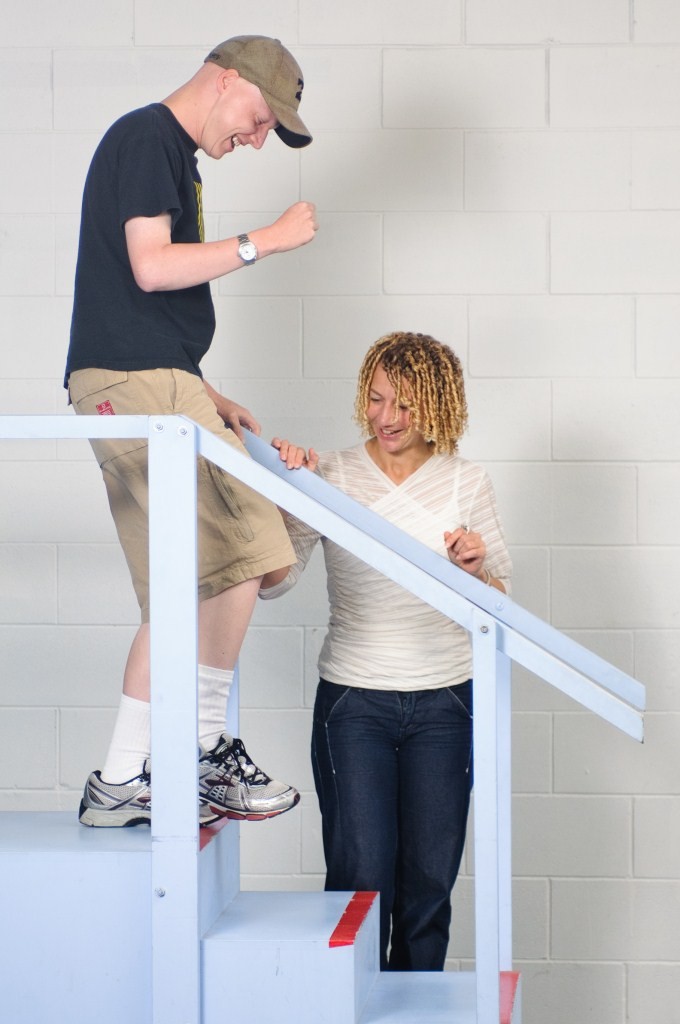 Therapist Suzie Mudge assisting a patient through physical rehabilitation by walking down stairs